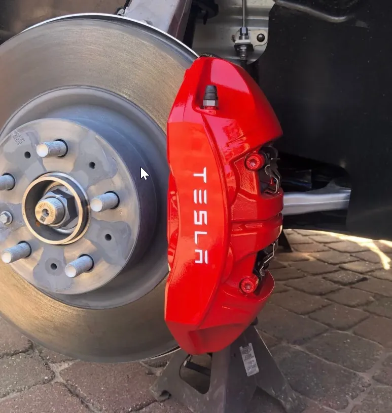 Tesla calipers — OEM red with custom branding.