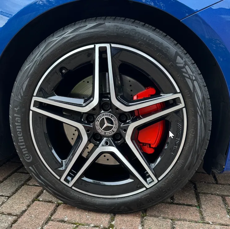 Mercedes-AMG 5-spoke alloy wheel after diamond cut refurbishment with red AMG brake calipers visible behind the spokes
