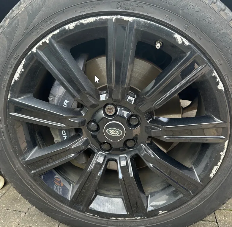 Range Rover split-spoke alloy wheel before refurbishment — kerb damage on outer rim
